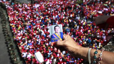 Un partidario de Chavez sostiene una fotografia de el sobre una multitud. 6 de marzo de 2013
