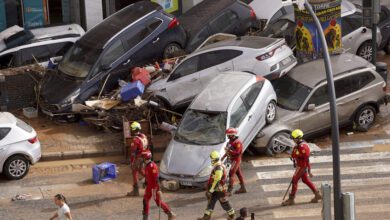 Servicios de emergencia cerca de coches apilados que fueron arrastrados por las inundaciones en Valencia, España, el 30 de octubre de 2024.