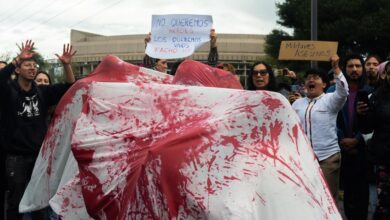 Manifestantes sostienen pancartas durante protestacontra la violencia en Ecuador.
