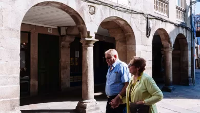 Una pareja de ancianos caminando de la mano por una calle de Santiago de Compostela, Galicia, España.