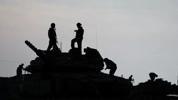 Silueta de soldados israelíes mientras están de pie sobre un tanque, cerca de la frontera entre Israel y Gaza