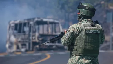 Un soldado monta guardia junto a un vehículo carbonizado tras ser incendiado en Cointzio, estado de Michoacán, México, el 22 de febrero de 2026.