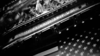 Fachada de la bolsa de Nueva York reflejada en un edificio de Wall Street