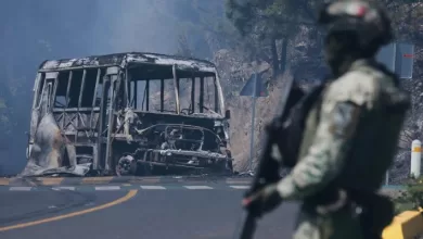 Un soldado monta guardia junto a un vehículo calcinado en Cointzio, Michoacán México, tras la muerte del líder del Cártel de Jalisco Nueva Generación